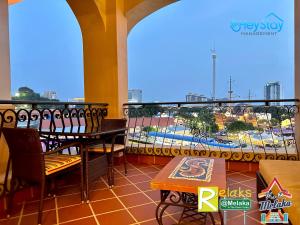 a balcony with tables and chairs and a view of a city at CasaDeRio DeluxRiverSuite Walk5minsToJonkerSt By Heystay Management in Melaka