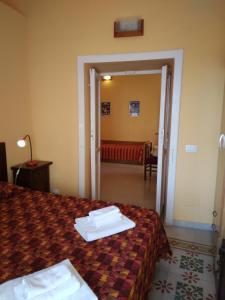 ein Hotelzimmer mit einem Bett und einem roten Sofa in der Unterkunft FORESTERIA DEL TEATRO in Agrigento