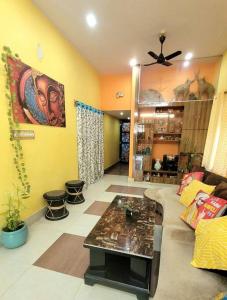 sala de estar con sofá y mesa en Feel the Bong vibes in a villa nearest to airport. en Calcuta