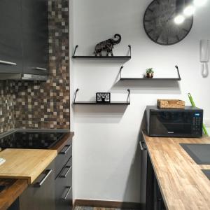 una cocina con estanterías en la pared con microondas en MAREZIA, en Corralejo