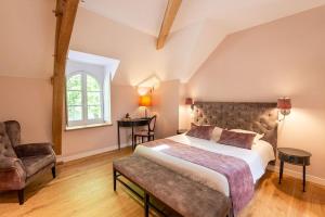 1 dormitorio con 1 cama, 1 silla y 1 ventana en Hotel Haras De La Potardiere en Crosmières