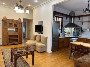 eine Küche und ein Wohnzimmer mit einem Sofa und einem Tisch in der Unterkunft Апартаменты на Бориса Гринченка in Kiew