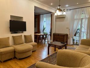 a living room with couches and a flat screen tv at Апартаменты на Бориса Гринченка in Kyiv