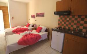 a hotel room with two beds and a sink at Athena Kythera in Dhiakofti
