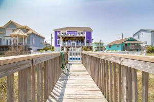 un paseo marítimo de madera que conduce a una casa en la playa en Oceanfront - Private Pool - Decks for Days, en Kure Beach
