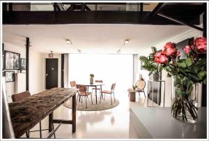 a living room with a table and a vase of roses at Ivory (car) loft / Carloft in Neuwied