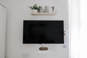 a flat screen tv hanging on a white wall at Bauhaus Studio - Sun Balcony - Rothschild Boulevard in Tel Aviv