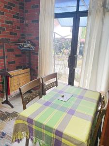 バヤンレパスにあるDusun Indah Cottage 2のテーブル、椅子2脚、テーブル、窓