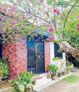 Una casa de ladrillo con flores rosas. en Dusun Indah Cottage 2 en Bayan Lepas