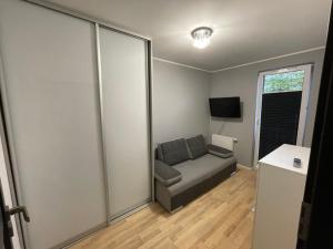 a living room with a couch and a television at Apartament Głowackiego 10 in Koszalin