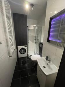 a bathroom with a sink and a shower and a toilet at Apartament Głowackiego 10 in Koszalin