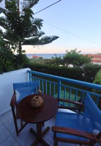 einen Tisch und Stühle auf einem Balkon mit Meerblick in der Unterkunft Athena Kythera in Diakofti