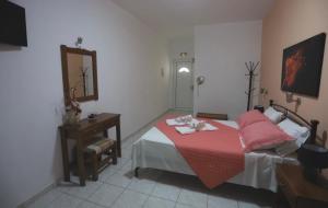 a bedroom with a bed with a red blanket at Athena Kythera in Dhiakofti