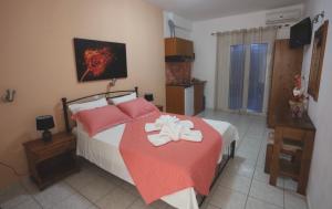 a bedroom with a bed with a red and white blanket at Athena Kythera in Diakofti