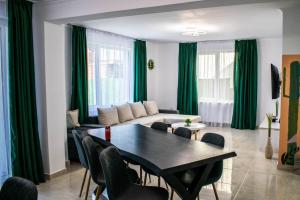 a living room with a table and green curtains at Casa LUCAS in Bistriţa
