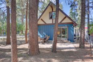 een hut in het bos met bomen bij Sherwood Cabin with Deck, Fire Pit and Lake Access! in Big Bear City