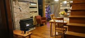 a living room with a fireplace and a christmas tree at The Little Cabin on Huckleberry in Rural Retreat