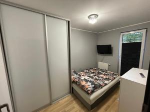 a small bedroom with a bed and a window at Apartament Głowackiego 10 in Koszalin