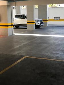 a white car parked inside of a parking garage at Classe Apart Hotel in Feira de Santana