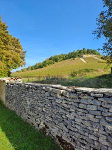 una pared de piedra con una colina en el fondo en Le val d Arlette, en Arsonval