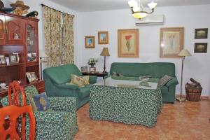 a living room with a green couch and a table at Chalet Carlos El Campito in Chiclana de la Frontera
