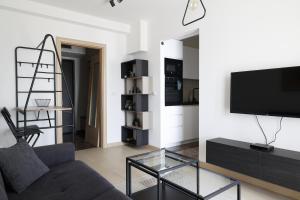- un salon avec un canapé et une télévision dans l'établissement Flat Apartments Skopje, à Skopje