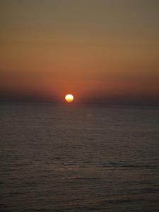 a sunset over the ocean with the sun in the horizon at Suite ortigia vista mare in Syracuse