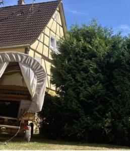 una casa con un garaje junto a un árbol en Haus Buckaroo – Rancho el Rosal en Bad Mergentheim