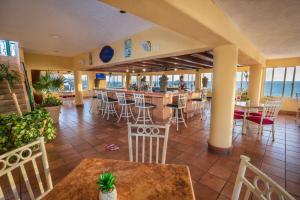 a restaurant with a bar with chairs and tables at Best Western Posada Freeman in Mazatlán