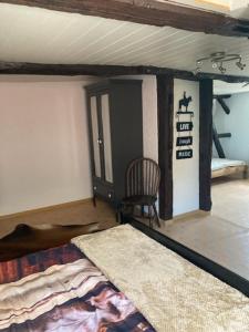 a bedroom with a bed and a chair in a room at Haus Buckaroo – Rancho el Rosal in Bad Mergentheim
