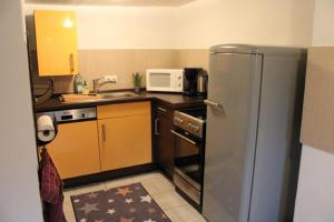 a kitchen with a stainless steel refrigerator and a microwave at Haus Buckaroo – Rancho el Rosal in Bad Mergentheim