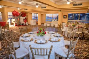 une salle de banquet avec une table, des nappes blanches et des chaises dans l'établissement Best Western Posada Freeman, à Mazatlán