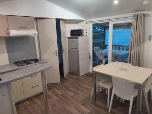 Boofzheim的住宿－Mobil-Home 6 personnes avec clim N' B025，厨房以及带桌椅的用餐室。