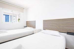 two beds in a white room with a window at Donna II 8-38 Apartment Levante Beach in Benidorm