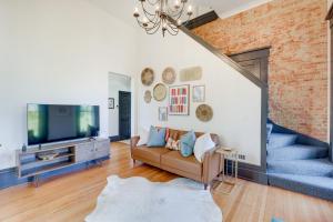 sala de estar con sofá y TV en Chic and Historic Apartment about 6 Mi to Louisville!, en New Albany