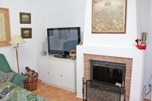 sala de estar con chimenea y TV en Chalet Carlos El Campito, en Chiclana de la Frontera