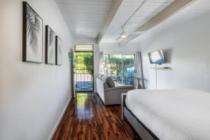 um quarto branco com uma cama e um sofá em Beach Paradise on a Budget: Charming Maui Studio Condo Just Steps from the Beach! em Kihei