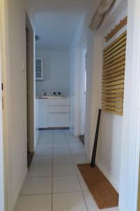 a hallway of a kitchen with white walls and white floors at Hradčany apartment with green energy in Prague