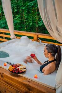 a woman sitting in a bath tub with a glass of wine at bungalov in Sapanca