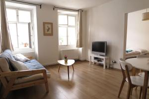 a living room with a couch and a tv at Hradčany apartment with green energy in Prague