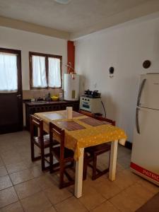 a kitchen with a table with chairs and a refrigerator at Luna de Cuarzo in Cafayate