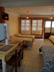 a room with two beds and a table and a kitchen at Luna de Cuarzo in Cafayate