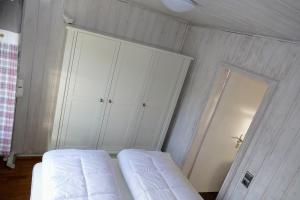 a bedroom with white cabinets and a white bed at Ferienhaus Bergblick in Meschede