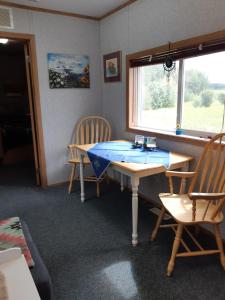 une chambre avec une table, deux chaises et une fenêtre dans l'établissement Peace and Quiet, à Lac La Biche