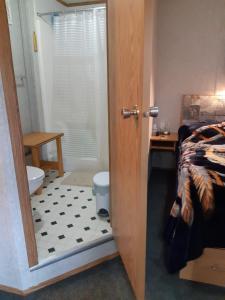 La salle de bains est pourvue d'une porte s'ouvrant sur une chambre avec des toilettes. dans l'établissement Peace and Quiet, à Lac La Biche