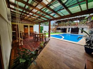 un patio con piscina, mesa y sillas en Hotel Liah's, en Tortuguero