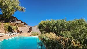 a swimming pool in front of a house with trees at Las Terrazas Hotel Boutique in Tilcara