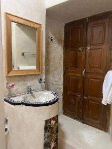 a bathroom with a sink and a mirror at Riad Dar Les Freres in Marrakech