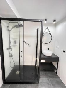W łazience znajduje się szklana kabina prysznicowa i umywalka. w obiekcie La Bella escondida piscina golf solarium w Maladze