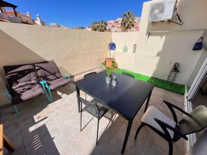 patio ze stołem i krzesłami na balkonie w obiekcie La Bella escondida piscina golf solarium w Maladze